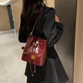 Sac seau en cuir verni bordeaux avec chaîne dorée et fermeture à cordon de serrage - Bucket Bag And Small Pouch / Bordeaux