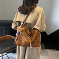 Grande borsa tote vintage marrone con ciondolo a orsetto indossata da una modella - Marrone