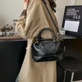 Bolso Boston negro clásico en cuero brillante con costuras blancas y correa ajustable - Negro
