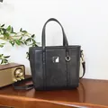 Elegante borsa a secchiello in pelle nera opaca con fibbia in metallo su tavolo - Solo Borsa / Nero
