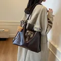 Dark brown leather tote bag with vintage buckle and cute bear charm shown on shoulder - 30*10*31 / Coffee