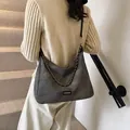 Retro grey suede tote bag with metal chain strap and fashion label shown on model - Black