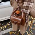 Borsa a tracolla in pelle marrone cerata con ciondolo a orsetto in un ambiente autunnale - Caffè con Pendente / 31*12*34