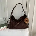 Detail der kaffeebraunen Wildleder-Tragetasche mit Donut-Anhänger und Metallschnallen - Mit Anhänger / Kaffeebraun