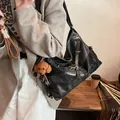 Grote zwarte kunstleren draagtas met een bruine teddybeer bedeltje en metalen gesp detail - Zwart