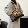 Vintage dark brown shoulder bag with cargo pockets and bear charm worn by a model - 32*11*21 / Coffee with Pendant