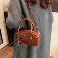 Polished brown pillow handbag with COIN ZDN logo and decorative bead charm - Brown