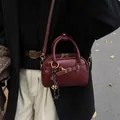 Retro burgundy mini bowling handbag with shoulder strap and stylish strap detail - No Pendant / Red