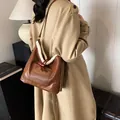 Brown leather underarm bag with white faux fur trim and ox horn button closure - 27*11.5*27 / Brown