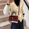 Retro deep wine red shoulder bag with gold clasp and checkered tassel on indoor stairs - Red