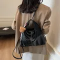 Vintage black hobo tote bag with white contrast stitching and a plush bear charm - Black With Rabbit Pendant