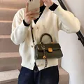 Olive green patent leather handbag with gold lock and decorative silk scarf accessory - Green