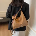 Vintage brown faux leather large tote bag shown on shoulder with plush bear charm - Khaki With Rabbit Pendant