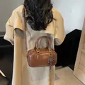 Vintage brown leather Boston bag with gold lettering and striped bow charm detail - Basic Style / Brown