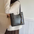Deep grey vintage leather tote bag with triangle plaque shown as an underarm shoulder bag - Standard Type / Black