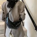 Glänzende schwarze Croissant-Umhängetasche mit Steppmuster am Modell getragen - Einheitsgröße / Schwarz