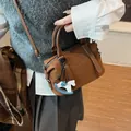 Borsa Boston in pelle marrone con logo a rilievo e ciondolo a forma di cavallo a dondolo - Stile con Ciondolo a Cavallo / Marrone Giallastro