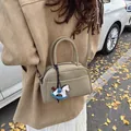 Chic beige mini Boston bag with horse charm and adjustable strap for autumn style - Green