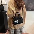 Black matte Boston mini bag with horse charm and adjustable strap shown on model - With Horse Charm (Black)