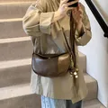 Vintage dark brown crescent shoulder bag in oil wax faux leather worn by a model - With Pendant / Khaki