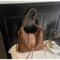 Detail of leopard print tote bag featuring brown leather strap and golden floral clasp - With Pendant / Leopard Print