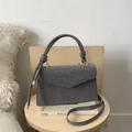 Detalle de bolso gris con estampado de leopardo, asa de nudo y herrajes metálicos dorados - Gris