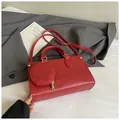 Detail of red crossbody bag with round coin purse on white cloth with grey blazer - Red