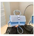 Detail of light blue woven handbag featuring a silver fluid metal handle and heart charm - Blue