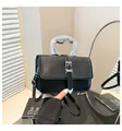 Detail of black leather bag featuring silver irregular metal handle and woven texture - Black