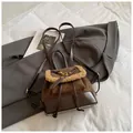 Detail of vintage suede bucket bag with faux shearling trim and glossy patent leather straps - Coffee without Pendant