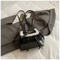 Detail of black mini backpack with white faux fur trim and gold hardware on grey suit - Black without Pendant