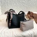 Chic black litchi leather bucket bag with silk scarf handle and striped inner pouch - With Pendant / Black