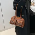 Brown gloss PU leather shoulder bag with vintage bows and pockets shown on a model - Brown