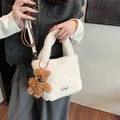 White faux fur bucket bag with a brown teddy bear charm and black woven label detail - With Charm / Beige