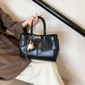 Bolso tote de cuero encerado negro con colgante de béisbol en pose elegante de mano - Con Colgante de Béisbol / Negro Con Colgante