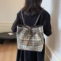 Brown and cyan plaid wool tote bag with leather straps on model in casual setting - Green Check