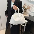Puffy white quilted drawstring tote bag with padded handle in minimalist setting - White