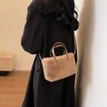 Khaki plush crossbody bag with leather handles and strap worn by a model - Khaki