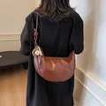 Brown leather croissant shoulder bag with contrast stitching and baseball charm - Caramel Brown