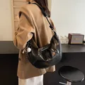 Black crescent shoulder bag with white contrast stitching and baseball charm - Black