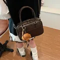 Retro dark brown boston handbag with suede stitching and cute dog charm shown in vintage room - 26*9*17cm / Brown