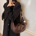 Dark brown crescent shoulder bag with contrast stitching and baseball charm on model - Coffee with Pendant