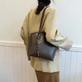 Grand cabas vintage marron foncé avec pendentif raquette porté à l'épaule par un mannequin - Marron