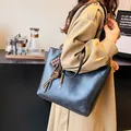 Grande borsa tote vintage in PU nero con ciondoli, indossata da una modella - con portachiavi / Nero Con Ciondolo