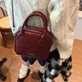 Vintage burgundy leather crossbody pillow bag with top handles shown on model outfit - 21*8*18 / Burgundy