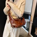 Bolso bandolera de media luna marrón vintage en cuero sintético brillante y pliegues - Caramelo Con Colgante