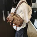 Braune Retro-Achseltasche mit Glanzeffekt und Schleifen-Detail am Model gezeigt - Braun