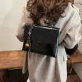 Zaino minimalista in pelle nera da donna con ciondolo a campana dorata e chiusura a girello - 25*10*19 / Nero Classico Con Pendaglio