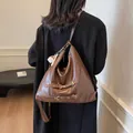 Retro brown large capacity hobo bag in leather with metal buckles and baseball charm - With Charm / Coffee