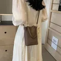 Mini dark brown pebbled leather bucket bag shown as a crossbody phone bag on model - 15*6*19 / Coffee